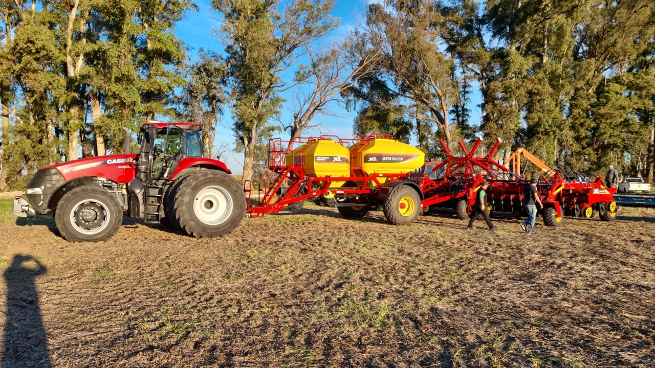 Sembradora de granos finos enganchada a un tractor, al atardecer